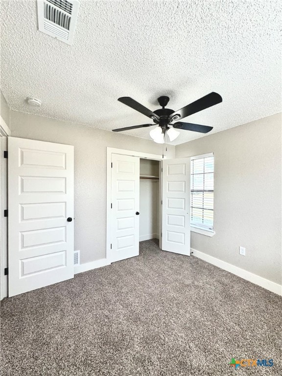 unfurnished bedroom featuring a closet, a textured ceiling, carpet flooring, and ceiling fan