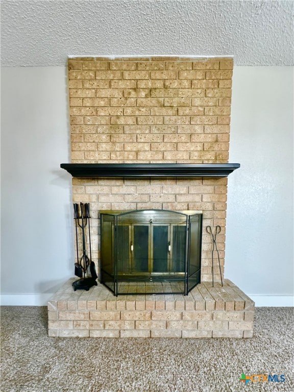 details featuring a brick fireplace, a textured ceiling, and carpet flooring