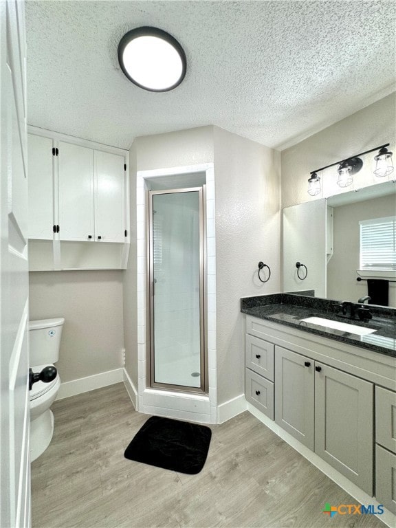 bathroom with hardwood / wood-style flooring, vanity, an enclosed shower, and a textured ceiling