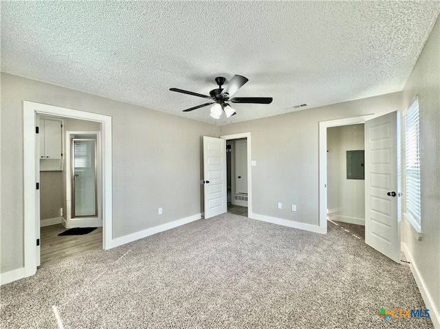 unfurnished bedroom with a textured ceiling, light colored carpet, and ceiling fan