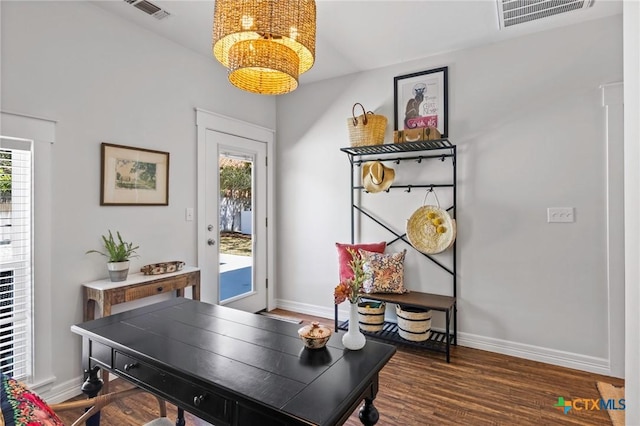 entryway with a chandelier, visible vents, baseboards, and wood finished floors