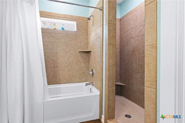 bathroom featuring a walk in closet, a tile shower, vanity, wood finished floors, and baseboards