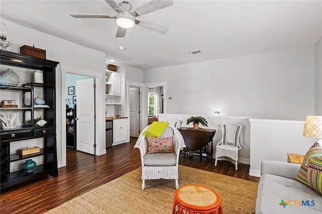 sitting room featuring a ceiling fan, visible vents, and wood finished floors