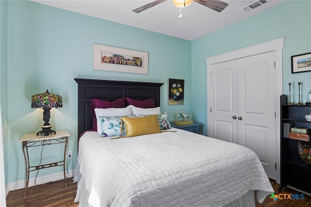 bedroom featuring baseboards, visible vents, a ceiling fan, wood finished floors, and a closet