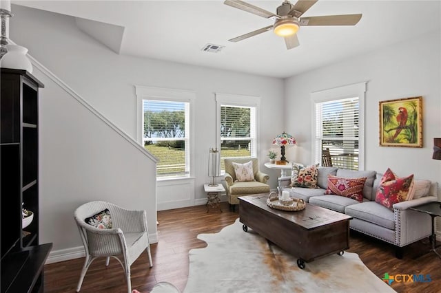 living room with ceiling fan, visible vents, a wealth of natural light, and wood finished floors