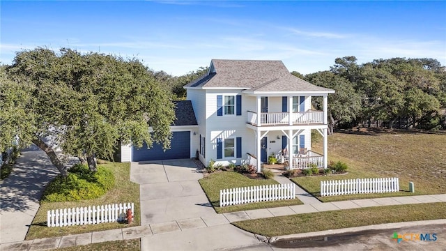 view of front facade with a garage, concrete driveway, a balcony, a fenced front yard, and covered porch