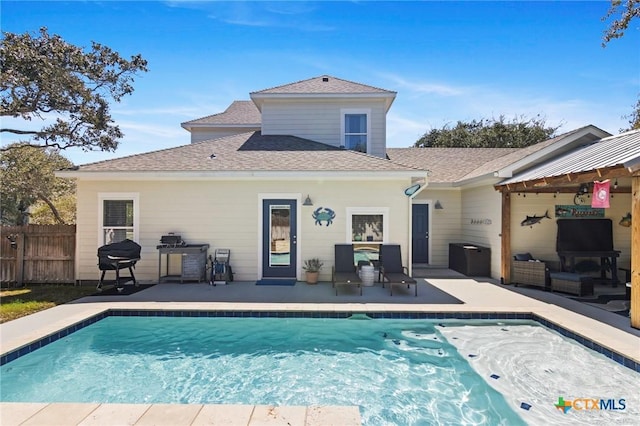 back of house with a patio, a shingled roof, outdoor lounge area, fence, and a fenced in pool