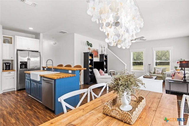 dining area featuring dark wood-style floors, recessed lighting, visible vents, and a notable chandelier