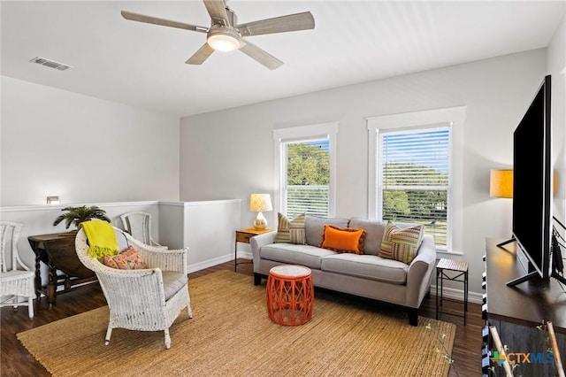 sitting room with wood finished floors, visible vents, and baseboards