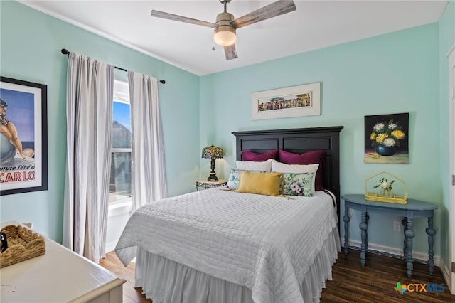 bedroom with ceiling fan, baseboards, and wood finished floors