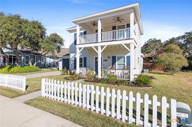 view of front of property with covered porch, a fenced front yard, a balcony, and a ceiling fan