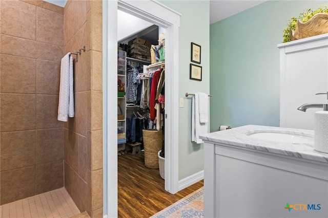 114 Boardwalk Ave, Rockport, TX 78382 - full bathroom featuring vanity, wood finished floors, a tile shower, and a spacious closet