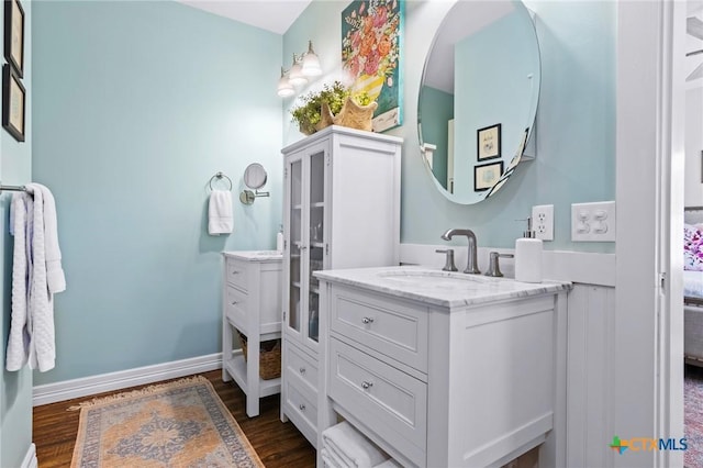 full bathroom with vanity, baseboards, and wood finished floors