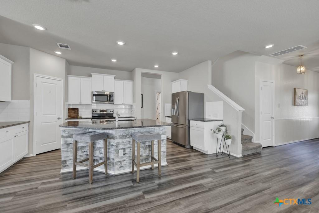 kitchen featuring dark wood finished floors, visible vents, and appliances with stainless steel finishes