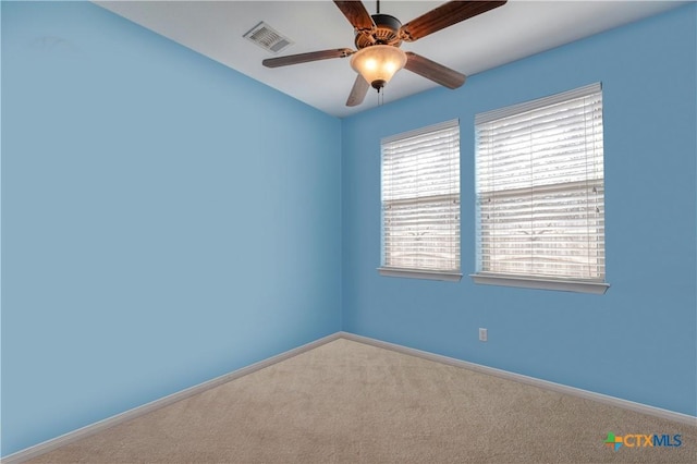 carpeted spare room featuring ceiling fan