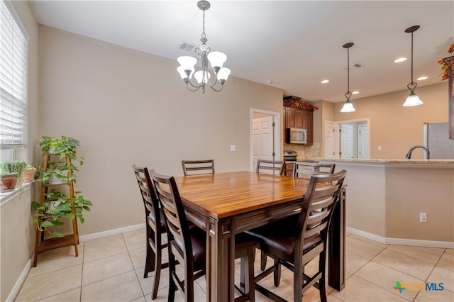 tiled dining room featuring a wealth of natural light and a notable chandelier