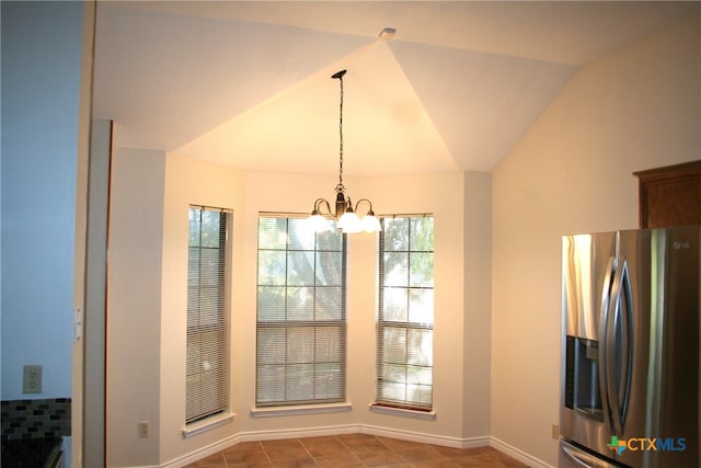 unfurnished dining area with tile patterned flooring, vaulted ceiling, and an inviting chandelier