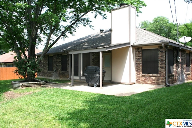 rear view of property with a lawn and a patio area