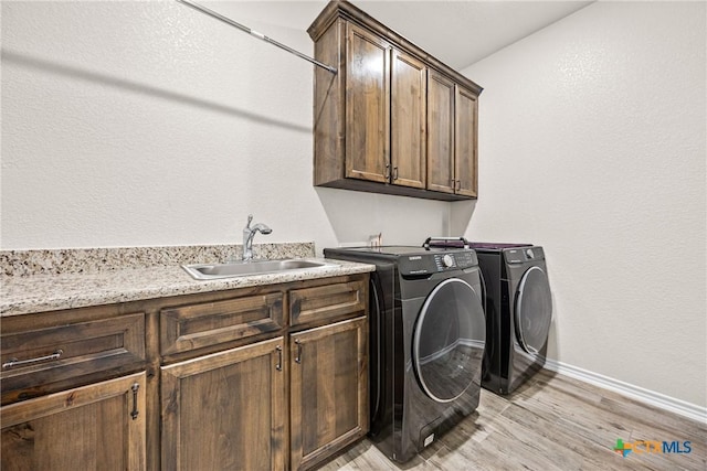 3424 Waggoner Dr, Belton, TX 76513 - laundry room with cabinet space, washing machine and clothes dryer, and light wood-style floors