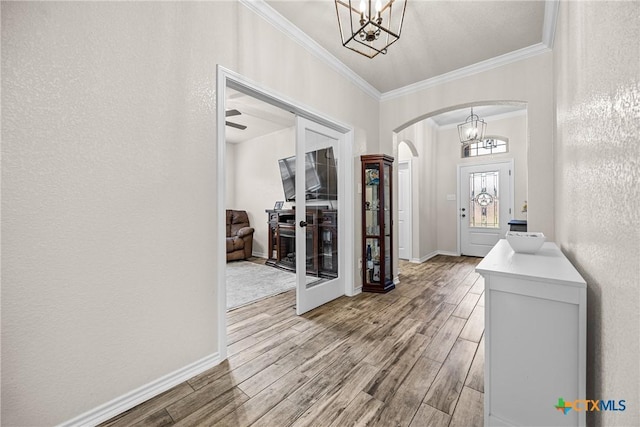 3424 Waggoner Dr, Belton, TX 76513 - foyer entrance featuring arched walkways, a chandelier, ornamental molding, and wood finished floors