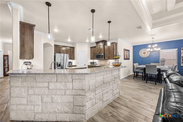 3424 Waggoner Dr, Belton, TX 76513 - kitchen with stainless steel appliances, crown molding, light stone countertops, light wood-type flooring, and dark brown cabinets