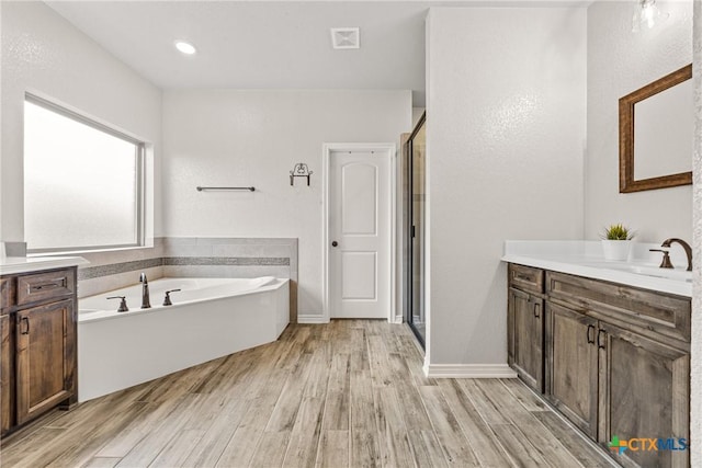3424 Waggoner Dr, Belton, TX 76513 - full bath featuring vanity, wood finished floors, a stall shower, and a bath