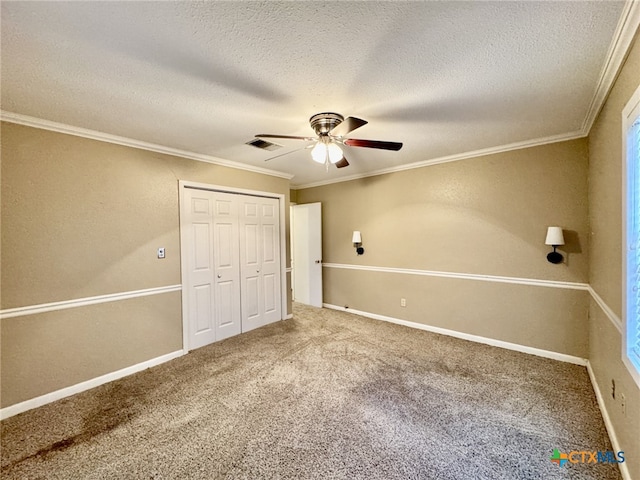 unfurnished bedroom featuring carpet floors, crown molding, a closet, visible vents, and a textured ceiling