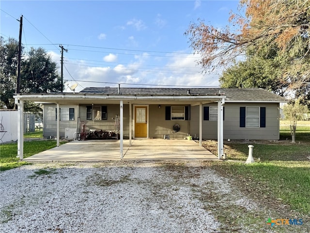 view of front of home featuring gravel driveway and a front lawn