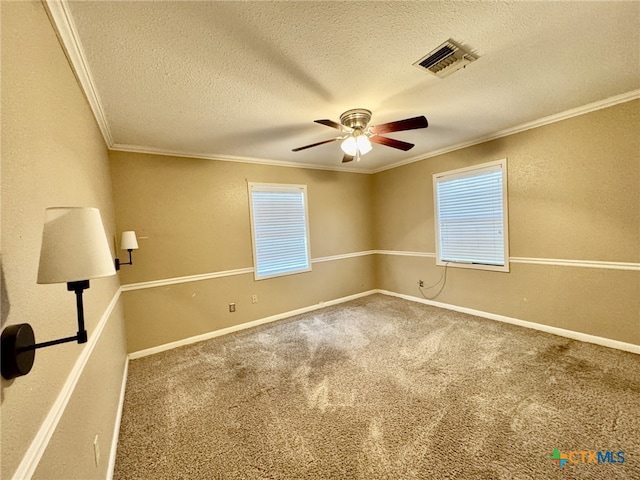 interior space with baseboards, a textured ceiling, visible vents, and crown molding