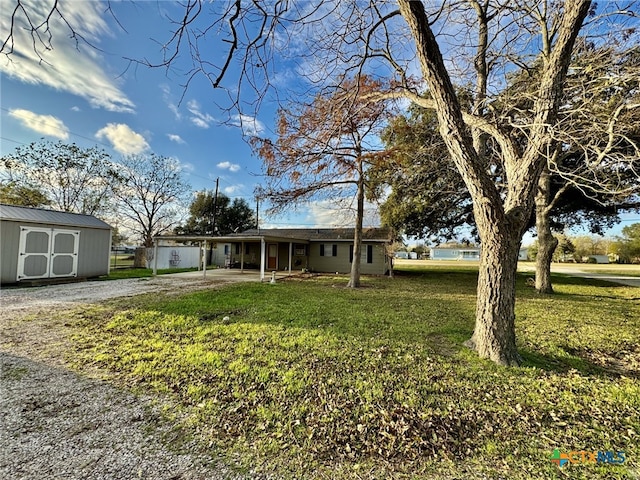 single story home with a front yard, an outdoor structure, driveway, and a storage unit