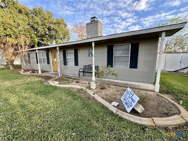 ranch-style house featuring a front yard and a chimney