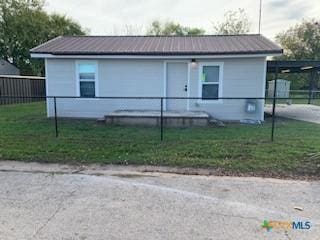 view of front of house featuring a carport and a front lawn