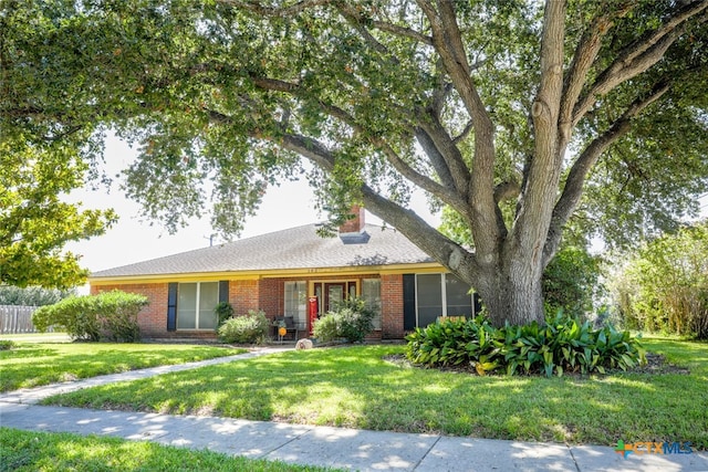 single story home with a sunroom and a front yard