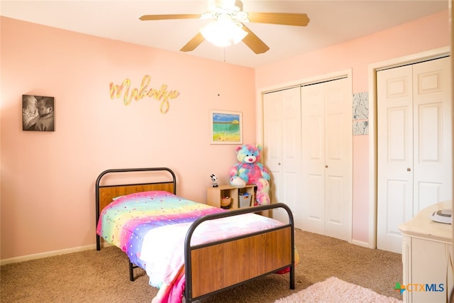 bedroom featuring ceiling fan, light carpet, and multiple closets