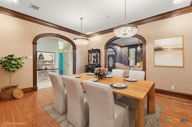 6 Carriage Sq, Waco, TX 76708 - dining room with arched walkways, light wood-type flooring, visible vents, and crown molding