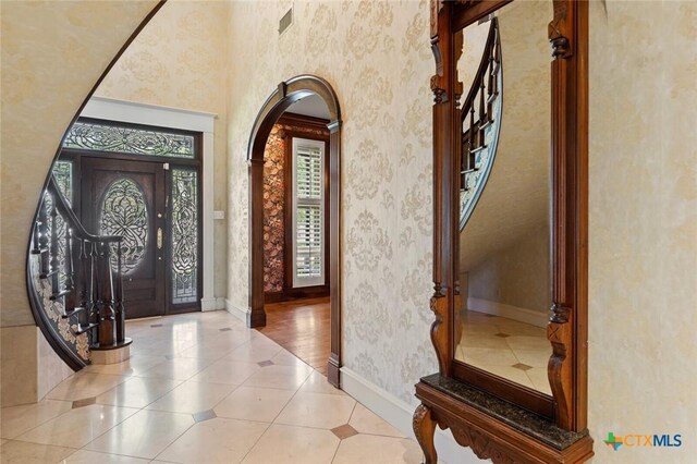 6 Carriage Sq, Waco, TX 76708 - foyer with wallpapered walls, tile patterned flooring, visible vents, arched walkways, and baseboards