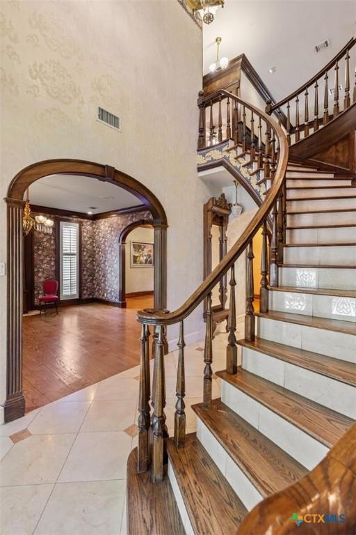 6 Carriage Sq, Waco, TX 76708 - staircase with arched walkways, a towering ceiling, baseboards, a notable chandelier, and visible vents