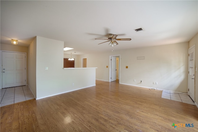 unfurnished living room with ceiling fan and light wood-type flooring