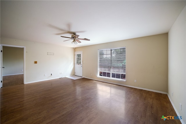 spare room with dark hardwood / wood-style flooring and ceiling fan