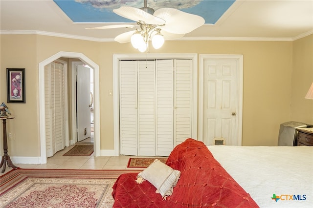 tiled bedroom featuring a skylight, ceiling fan, and crown molding