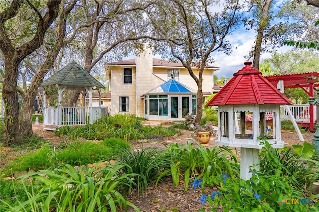 back of property featuring a gazebo