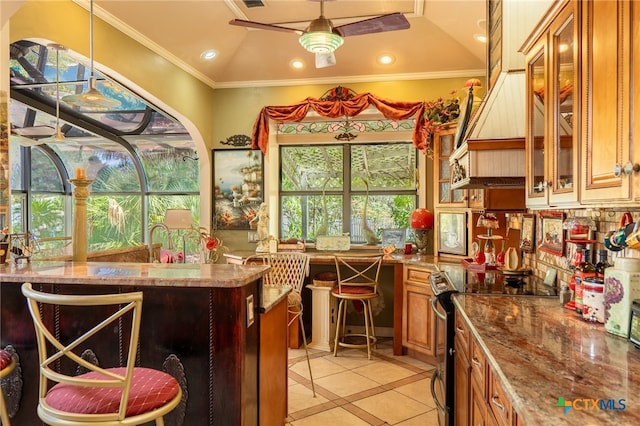 kitchen with light tile patterned flooring, ceiling fan, stainless steel electric range, stone counters, and crown molding