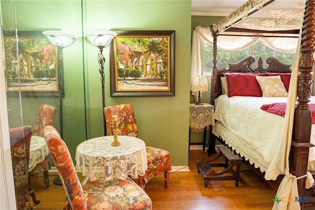 bedroom featuring wood-type flooring and crown molding