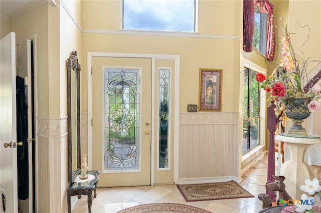 entryway featuring a wealth of natural light, light tile patterned floors, and crown molding