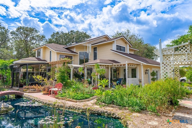 rear view of property featuring a swimming pool, a patio, and a gazebo