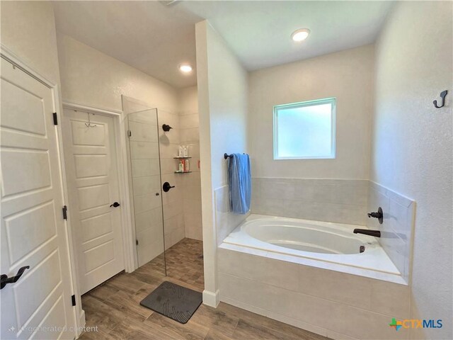 2635 Belle Hubbard Trl, Belton, TX 76513 - bathroom with a garden tub, wood finished floors, and walk in shower