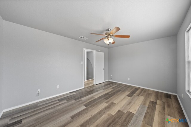 unfurnished bedroom featuring dark hardwood / wood-style floors and ceiling fan