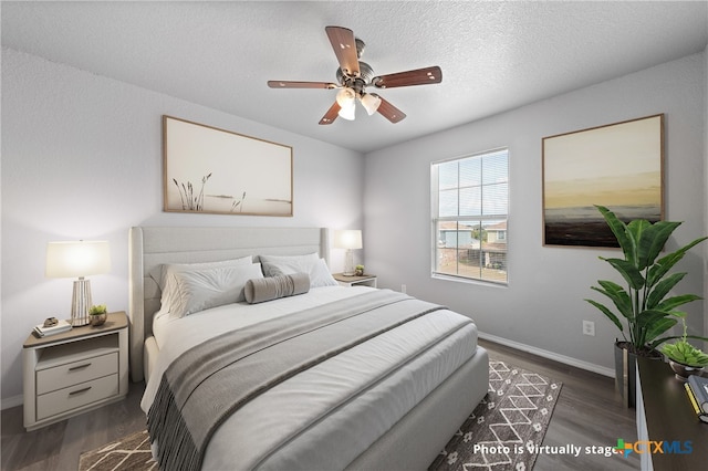 bedroom with dark hardwood / wood-style flooring, a textured ceiling, and ceiling fan