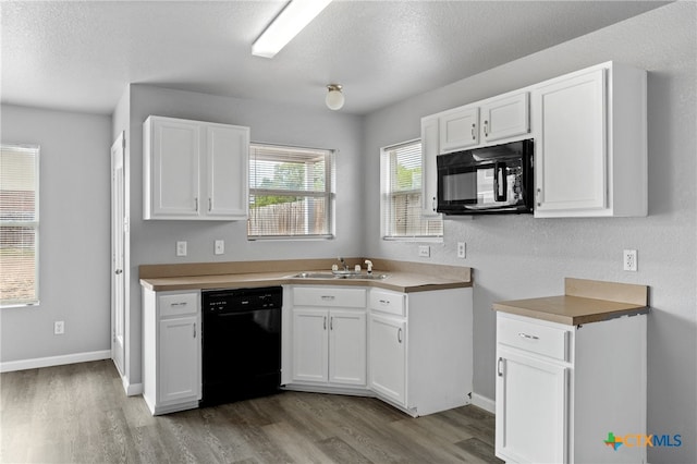 kitchen featuring hardwood / wood-style floors, white cabinetry, sink, and black appliances