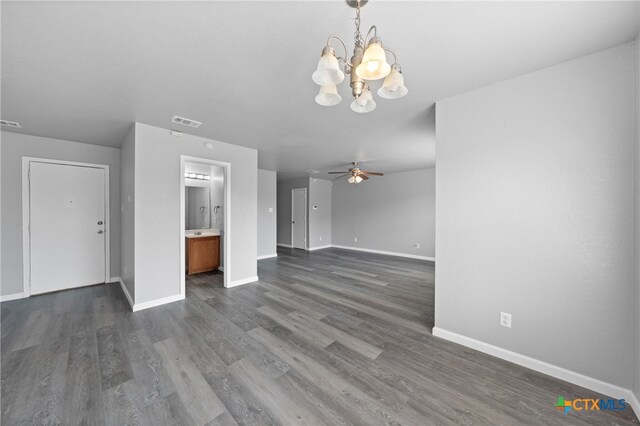 unfurnished living room featuring ceiling fan with notable chandelier and dark hardwood / wood-style floors